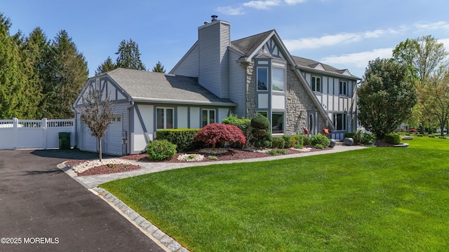 50 Locust Ct, Freehold, NJ 07728 - tudor house featuring asphalt driveway, a garage, a chimney, board and batten siding, and stone siding