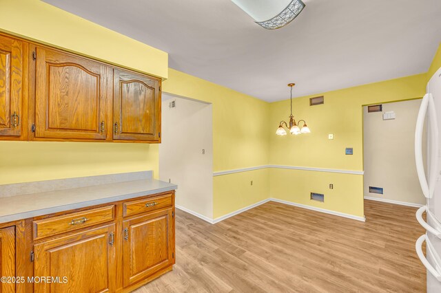 40 Everest Dr N, Brick, NJ 08724 - kitchen with brown cabinets, light wood-style floors, freestanding refrigerator, decorative light fixtures, and baseboards