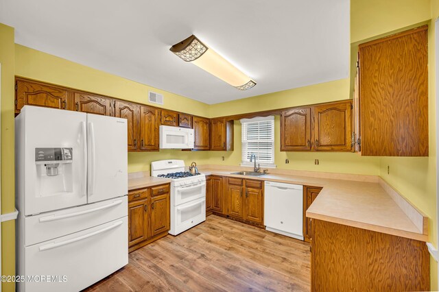 40 Everest Dr N, Brick, NJ 08724 - kitchen with white appliances, a sink, brown cabinets, light wood-type flooring, and light countertops