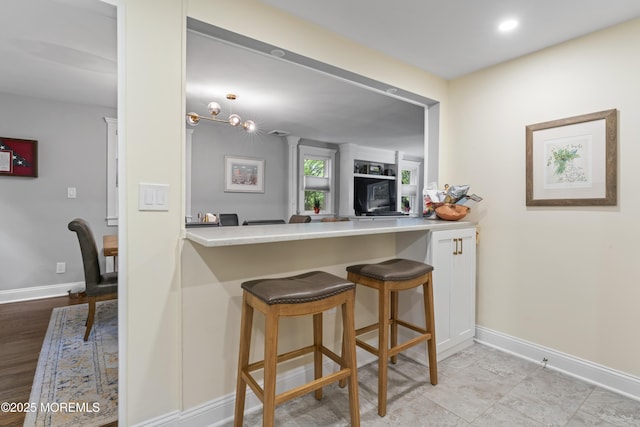 116 Manor Dr, Red Bank, NJ 07701 - kitchen featuring baseboards, a desk, a breakfast bar, and a peninsula