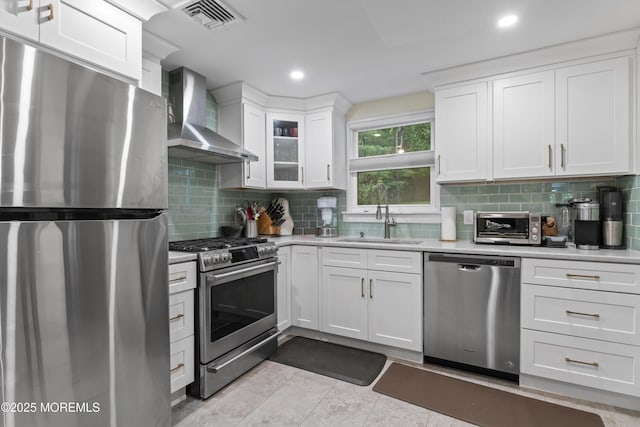 116 Manor Dr, Red Bank, NJ 07701 - kitchen featuring appliances with stainless steel finishes, wall chimney exhaust hood, a sink, light countertops, and white cabinets