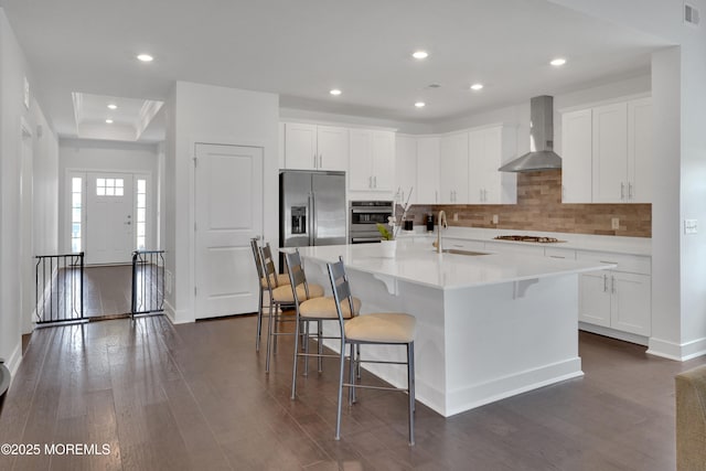 69 Starlight Dr, Monroe, NJ 08831 - kitchen with wall chimney range hood, a sink, appliances with stainless steel finishes, backsplash, and a tray ceiling