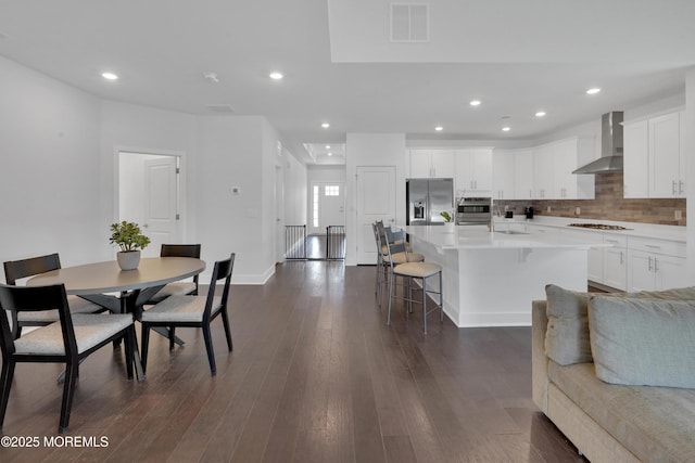 69 Starlight Dr, Monroe, NJ 08831 - kitchen featuring stainless steel appliances, wall chimney exhaust hood, a kitchen breakfast bar, decorative backsplash, and an island with sink