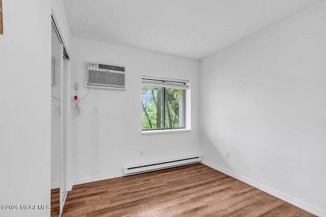 1320 State Route 71 Unit 202, Belmar, NJ 07719 - spare room featuring baseboard heating, a wall unit AC, wood finished floors, and baseboards