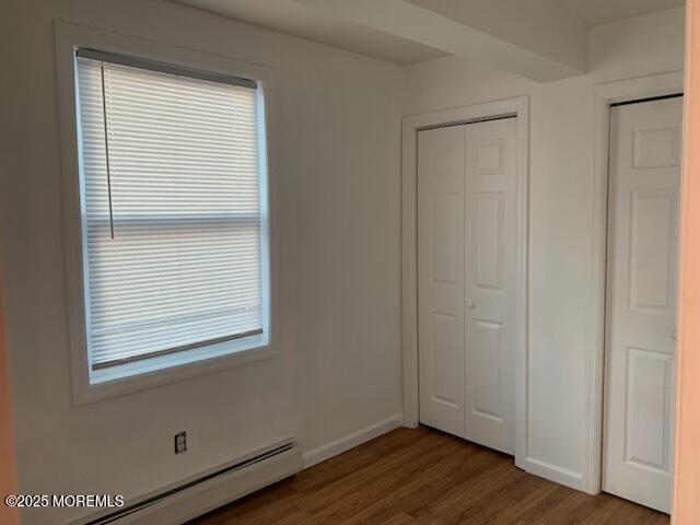 128 Hamilton Ave, Seaside Heights, NJ 08751 - unfurnished bedroom featuring baseboard heating, wood finished floors, and a closet