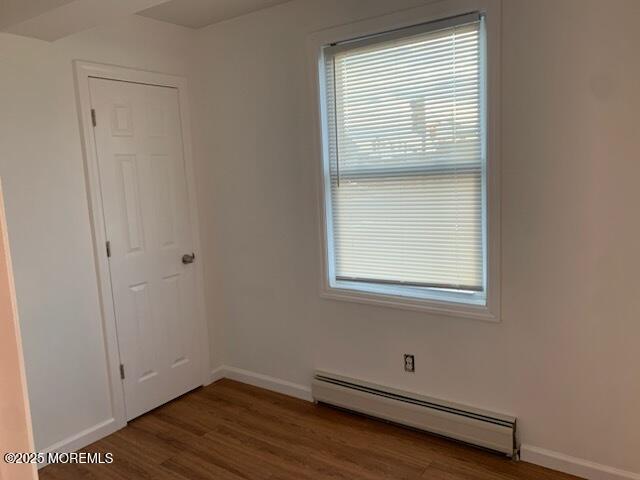 128 Hamilton Ave, Seaside Heights, NJ 08751 - spare room with a baseboard heating unit, wood finished floors, and healthy amount of natural light