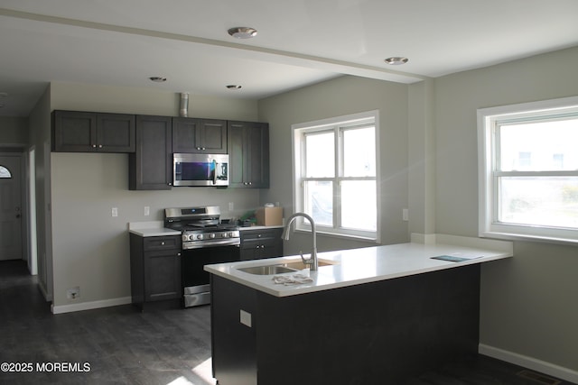 519 Roosevelt Ave, Carteret, NJ 07008 - kitchen with appliances with stainless steel finishes, a sink, light countertops, baseboards, and dark wood-style flooring