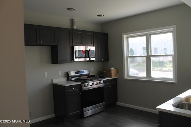 519 Roosevelt Ave, Carteret, NJ 07008 - kitchen featuring appliances with stainless steel finishes, baseboards, light countertops, dark wood-style floors, and dark cabinetry