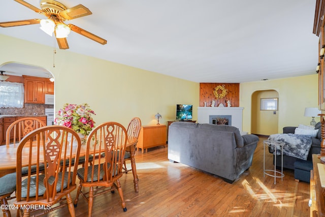 18 Lillie Rd, Toms River, NJ 08753 - dining space featuring arched walkways, ceiling fan, a fireplace, and light wood-style floors