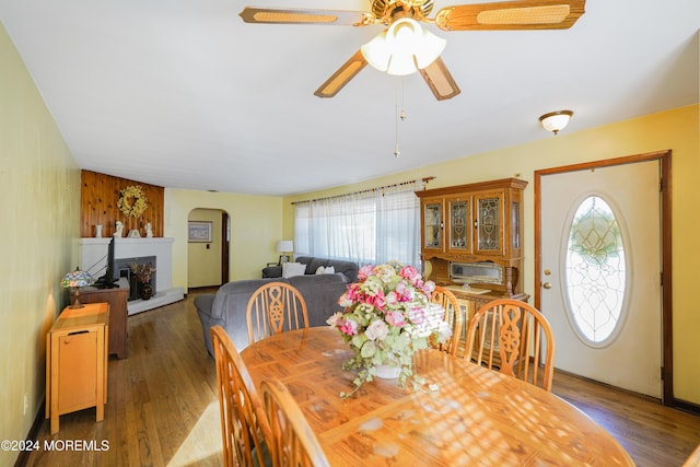 18 Lillie Rd, Toms River, NJ 08753 - dining area with arched walkways, ceiling fan, wood finished floors, and a fireplace with raised hearth
