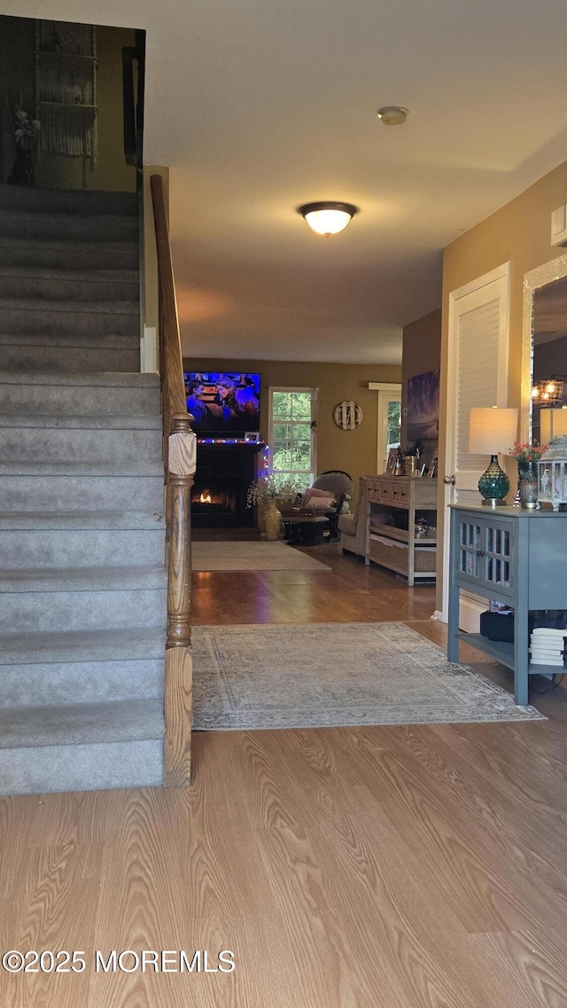 25 Atlantis Ter, Freehold, NJ 07728 - staircase featuring a warm lit fireplace and wood finished floors