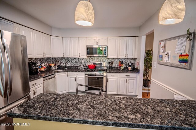 25 Atlantis Ter, Freehold, NJ 07728 - kitchen featuring stainless steel appliances, white cabinets, decorative backsplash, a sink, and hanging light fixtures