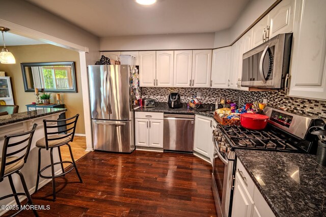 25 Atlantis Ter, Freehold, NJ 07728 - kitchen with stainless steel appliances, dark wood finished floors, white cabinetry, and decorative backsplash