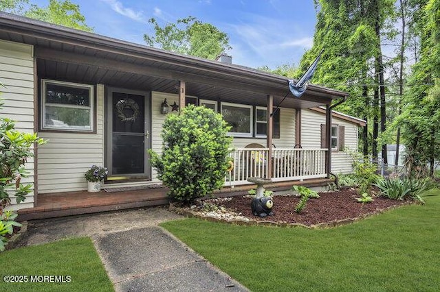 24 Delaware Trl, Browns Mills, NJ 08015 - doorway to property with covered porch and a lawn