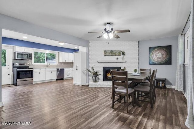 24 Delaware Trl, Browns Mills, NJ 08015 - dining space with ceiling fan, dark wood-type flooring, a fireplace, and baseboards