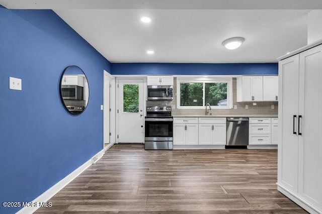 24 Delaware Trl, Browns Mills, NJ 08015 - kitchen with appliances with stainless steel finishes, a sink, decorative backsplash, white cabinetry, and dark wood-style floors