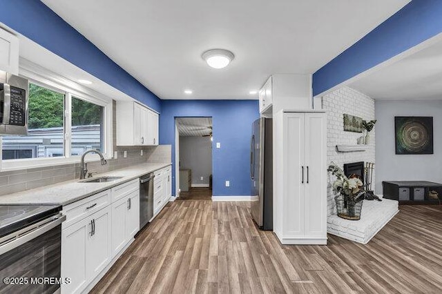 24 Delaware Trl, Browns Mills, NJ 08015 - kitchen featuring appliances with stainless steel finishes, a sink, white cabinetry, and decorative backsplash