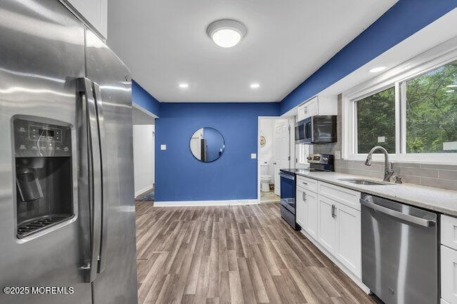24 Delaware Trl, Browns Mills, NJ 08015 - kitchen with stainless steel appliances, a sink, white cabinetry, light countertops, and baseboards