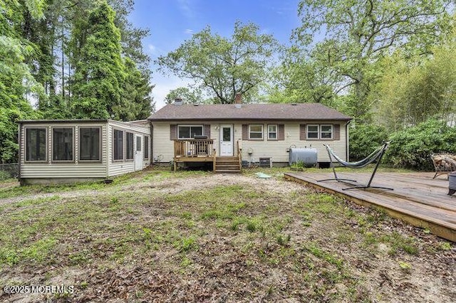 24 Delaware Trl, Browns Mills, NJ 08015 - rear view of house featuring oil tank, a wooden deck, a sunroom, a chimney, and a yard