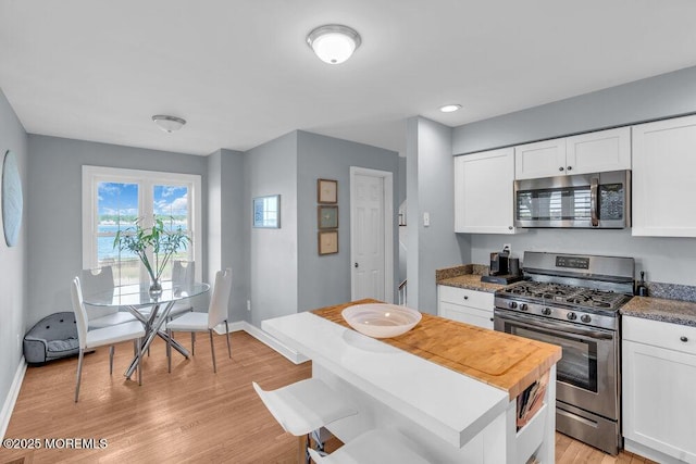 332 Seaview Cir, Neptune Township, NJ 07753 - kitchen featuring stainless steel appliances, white cabinets, light wood-type flooring, and baseboards