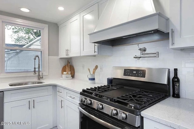126 Seabreeze Ave, North Middletown, NJ 07748 - kitchen featuring stainless steel gas stove, custom range hood, a sink, white cabinets, and decorative backsplash