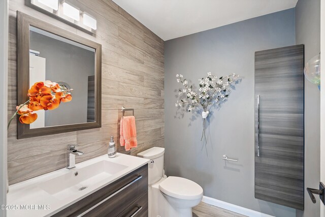 37 Florence Ave, Leonardo, NJ 07737 - half bathroom with toilet, vanity, tasteful backsplash, wooden walls, and tile walls