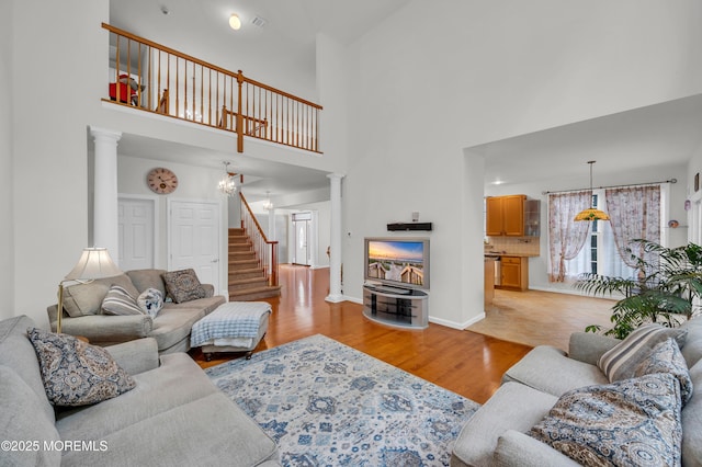 208 Bradwick Way, Marlboro, NJ 07746 - living area with ornate columns, a towering ceiling, light wood finished floors, stairs, and baseboards