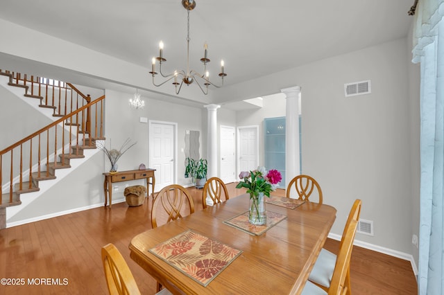 208 Bradwick Way, Marlboro, NJ 07746 - dining room with baseboards, ornate columns, wood finished floors, stairs, and a chandelier