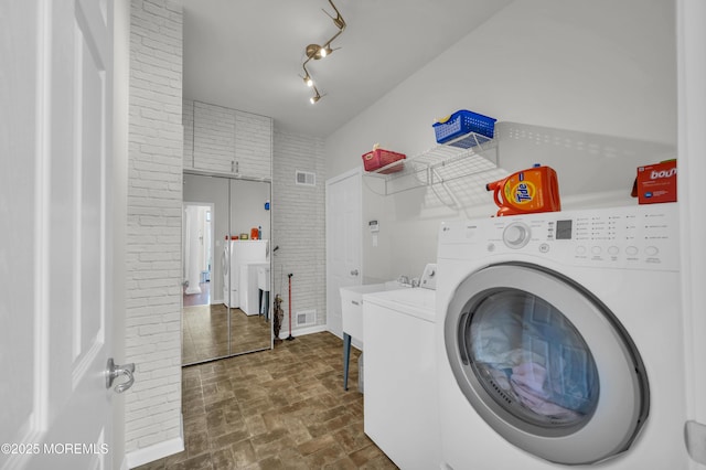 208 Bradwick Way, Marlboro, NJ 07746 - laundry room with independent washer and dryer, brick patterned floors, and brick wall
