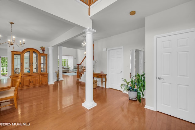 208 Bradwick Way, Marlboro, NJ 07746 - foyer entrance featuring ornate columns, light wood-style floors, a chandelier, stairway, and baseboards
