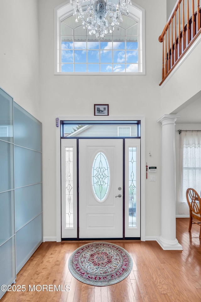 208 Bradwick Way, Marlboro, NJ 07746 - foyer entrance with ornate columns, wood-type flooring, a chandelier, and a towering ceiling