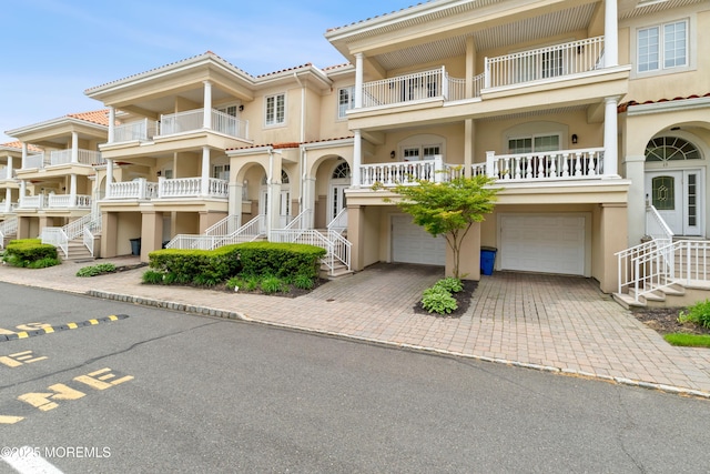 17 Riviera Dr, Long Branch, NJ 07740 - view of front of house featuring an attached garage, stucco siding, stairway, decorative driveway, and a tile roof