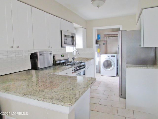 313 Merrimac Rd, Forked River, NJ 08731 - kitchen with washer / clothes dryer, stainless steel appliances, water heater, a sink, and tasteful backsplash