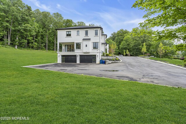 30 Winchester Ln, Holmdel, NJ 07733 - back of property featuring a garage, stucco siding, driveway, and a lawn