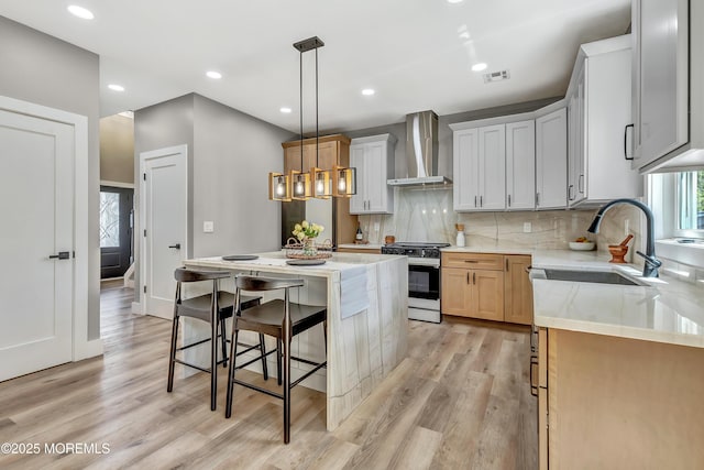 7 Cardinal Ave, Brick, NJ 08724 - kitchen with range with gas cooktop, wall chimney range hood, a sink, light wood finished floors, and backsplash