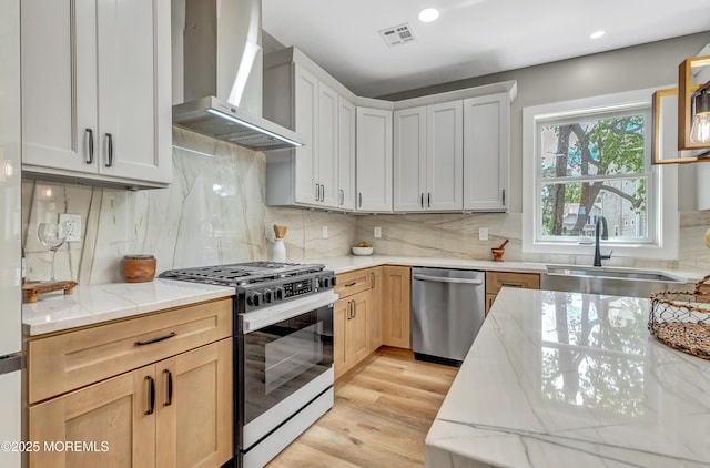 7 Cardinal Ave, Brick, NJ 08724 - kitchen with range with gas cooktop, wall chimney exhaust hood, stainless steel dishwasher, a sink, and light stone countertops
