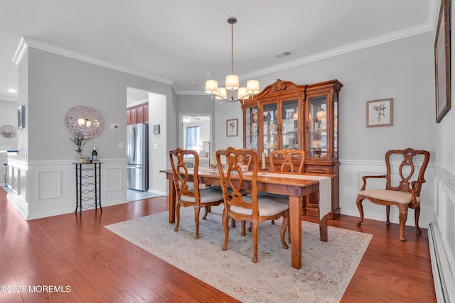 28 Pierhead Dr, Barnegat, NJ 08005 - dining space with baseboard heating, a chandelier, ornamental molding, dark wood finished floors, and wainscoting