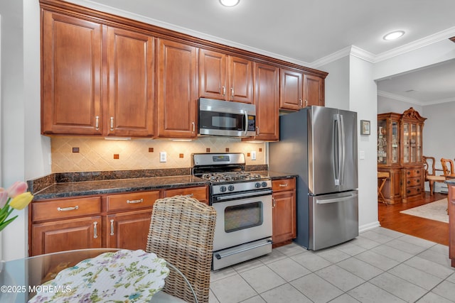 28 Pierhead Dr, Barnegat, NJ 08005 - kitchen with appliances with stainless steel finishes, crown molding, light tile patterned flooring, tasteful backsplash, and brown cabinets