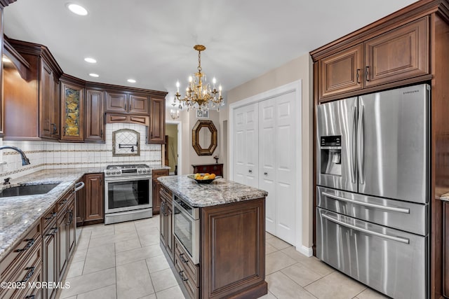 16 W Ave, Gladstone, NJ 07934 - kitchen with appliances with stainless steel finishes, a chandelier, backsplash, light stone counters, and recessed lighting
