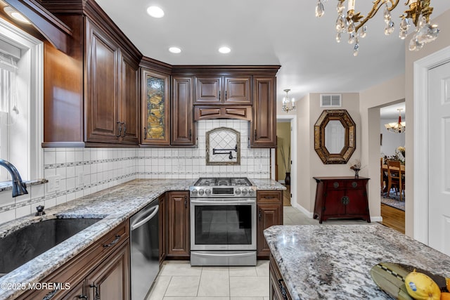 16 W Ave, Gladstone, NJ 07934 - kitchen with a chandelier, appliances with stainless steel finishes, light tile patterned flooring, tasteful backsplash, and light stone counters