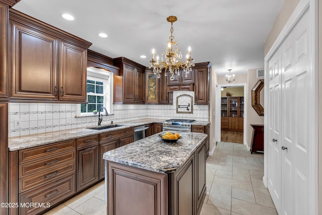 16 W Ave, Gladstone, NJ 07934 - kitchen with appliances with stainless steel finishes, a chandelier, backsplash, light stone counters, and pendant lighting