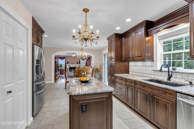 16 W Ave, Gladstone, NJ 07934 - kitchen with appliances with stainless steel finishes, arched walkways, a chandelier, a center island, and light stone countertops