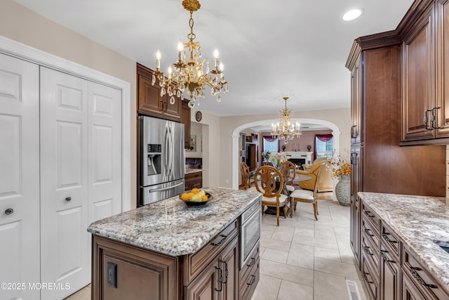16 W Ave, Gladstone, NJ 07934 - kitchen with stainless steel appliances, arched walkways, a chandelier, light stone countertops, and hanging light fixtures