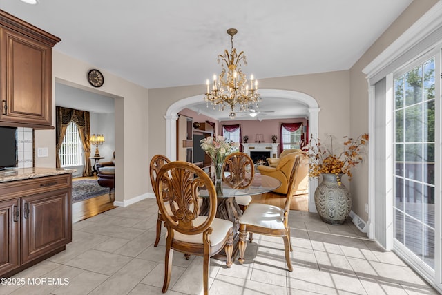16 W Ave, Gladstone, NJ 07934 - dining area with arched walkways, plenty of natural light, light tile patterned flooring, and a chandelier