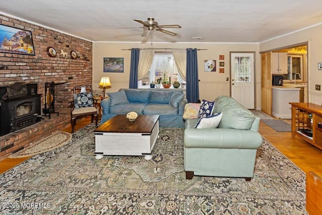 75 Brown Rd, Howell, NJ 07731 - living room with a wood stove, wood finished floors, a ceiling fan, and ornamental molding