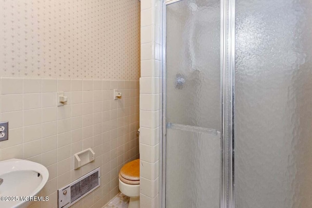 75 Brown Rd, Howell, NJ 07731 - bathroom with tile walls, a stall shower, toilet, wallpapered walls, and wainscoting