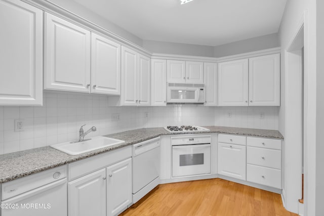 7 Centre St Unit 1303, Ocean Twp, NJ 07712 - kitchen with white appliances, a sink, white cabinetry, and light wood-type flooring
