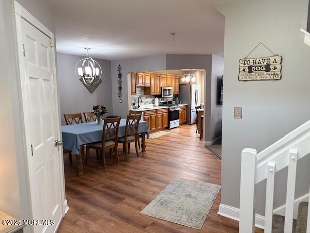 372 Oak Knoll Dr, Manalapan, NJ 07726 - dining space with a chandelier, light wood-style floors, and baseboards