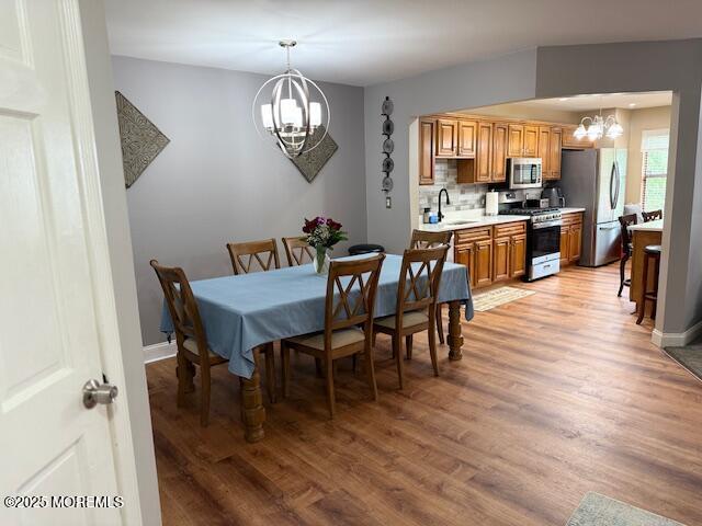 372 Oak Knoll Dr, Manalapan, NJ 07726 - dining space with a chandelier, light wood-type flooring, and baseboards