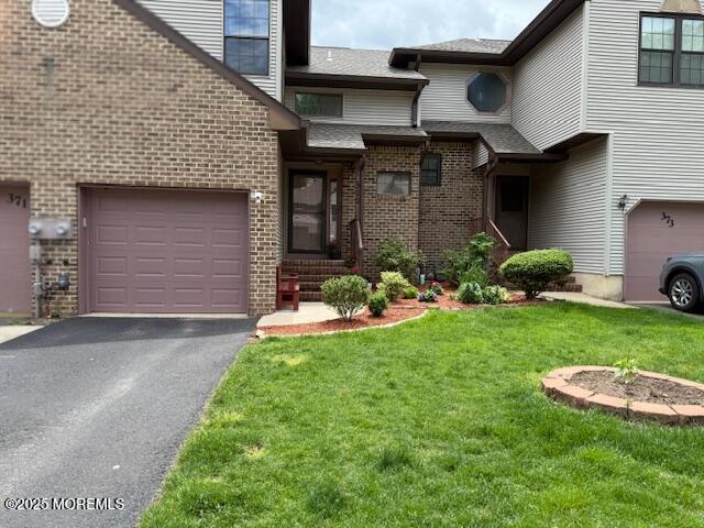 372 Oak Knoll Dr, Manalapan, NJ 07726 - view of front of house with brick siding, a front lawn, asphalt driveway, an attached garage, and a shingled roof